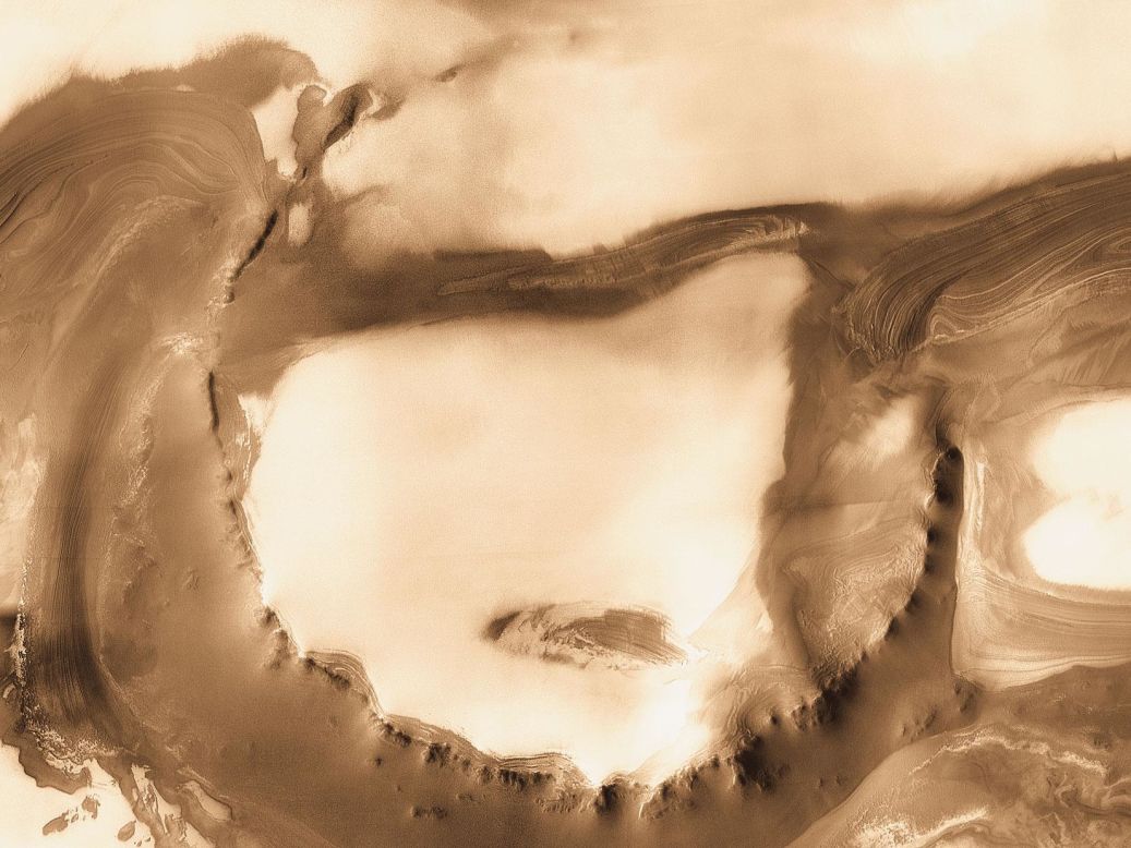 Capas de hielo y tierra se ven en el cráter Udzha, de 45 kilómetros de ancho. Esta imagen fue tomada por el Mars Odyssey Orbiter de la NASA en 2010.
