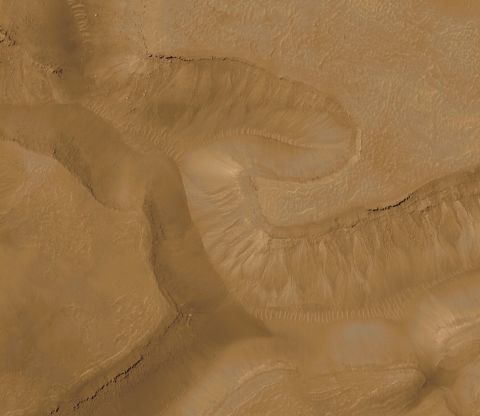 Pictured is a series of troughs and layered mesas in the Gorgonum Chaos region of Mars in 2008. This photo was taken by Mars Orbiter Camera on the Mars Global Surveyor.