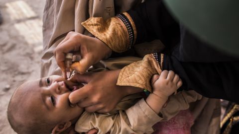 A three-month-old infant receives polio vaccination drops from his mother at a camp in Jalozai, Pakistan on July 13.