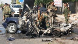 Syrian policemen inspect the site of a car bomb explosion on Mazzeh highway in the capital Damascus on July 13.