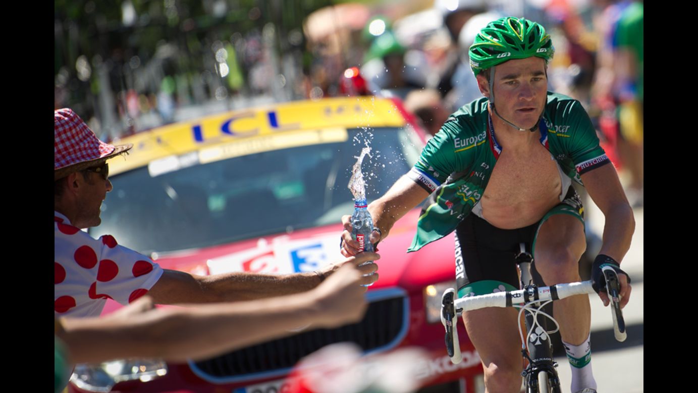 Stage winner Thomas Voeckler of France grabs a bottle of water from a fan as he climbs the final pass before the finish Wednesday, July 18, during the 197-kilometer (122-mile) race through the Pyrenees from Pau to Bagnères-de-Luchon. 