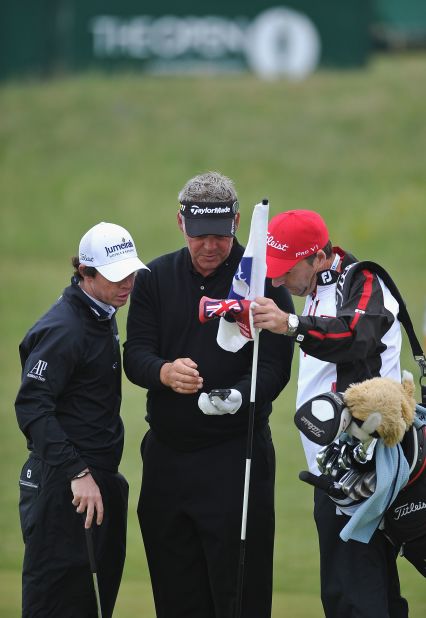 For the first time since 2006, the British Open will allow fans to bring phones onto the golf course when it gets underway on Thursday. Darren Clarke (center), who went on to lift the Claret Jug in 2011, and Rory McIlroy can be seen here checking out a phone during a practice round ahead of last year's event.
