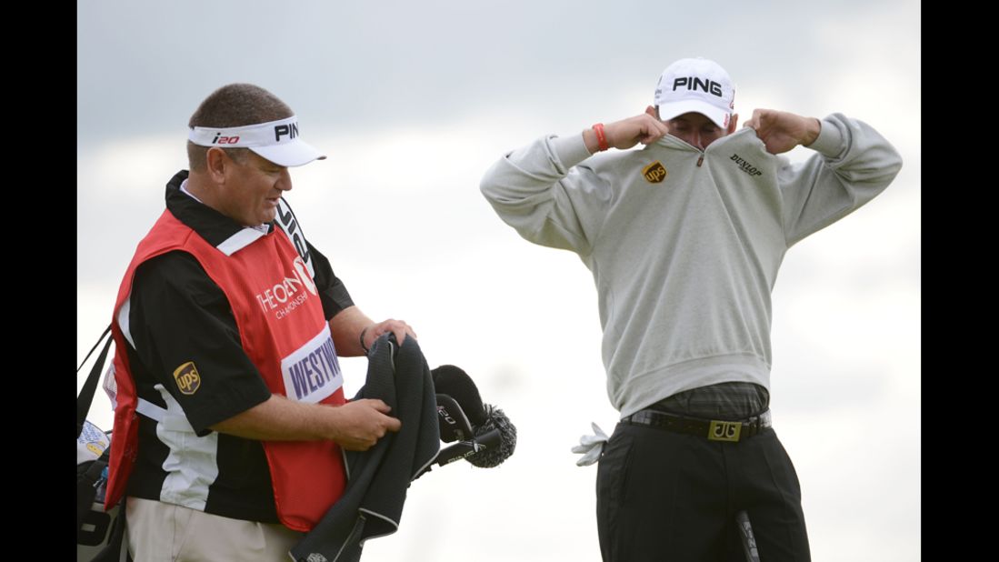 With caddie Michael Waite at his side, Lee Westwood of England removes his jacket during the first round Thursday.