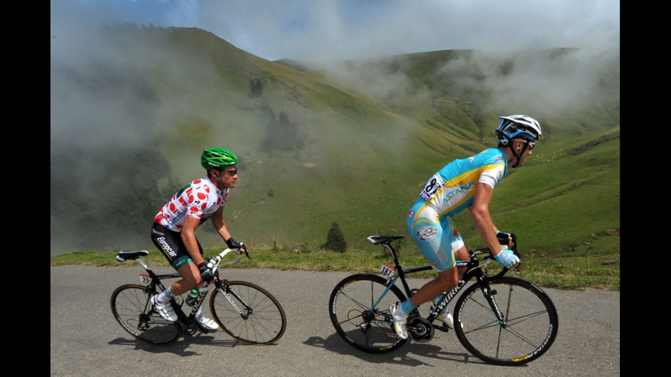 Thomas Voeckler of France and Fredrik Kessiakoff of Sweden ride in a breakaway group together through the Pyrenees mountains.