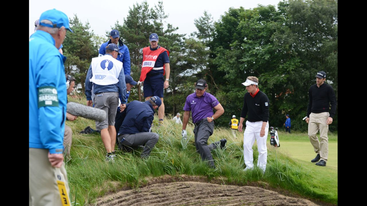Phil Mickelson of the United States searches for his golf ball on the eighth hole Thursday.