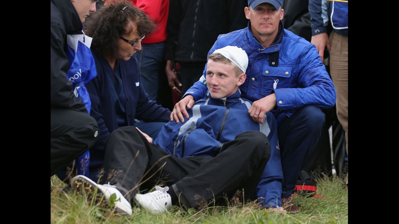 Jason Blue of Bristol gets medical attention after he was struck by Rory McIlroy's golf ball on the 15th hole on Thursday.