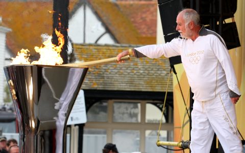 Keith Leech of Hastings uses the Olympic flame to light the cauldron in Hastings on Tuesday, July 17.