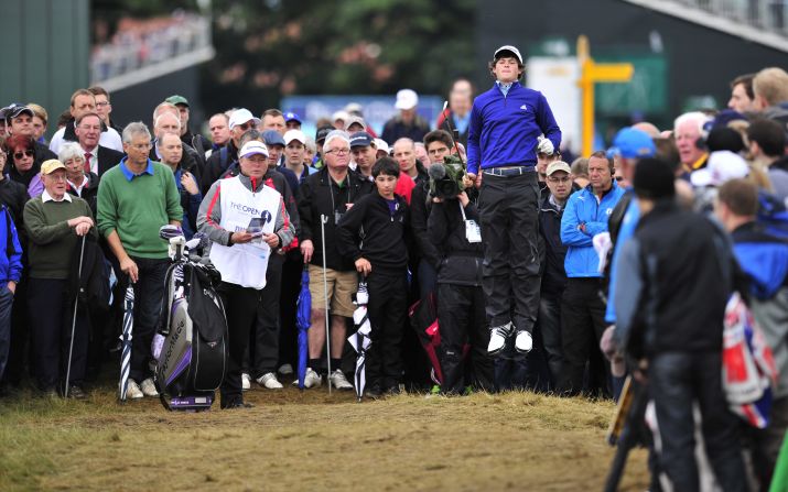 Amateur golfer Alan Dunbar of Northern Ireland leaps up to get a better view on the second hole during the first round of play Thursday.