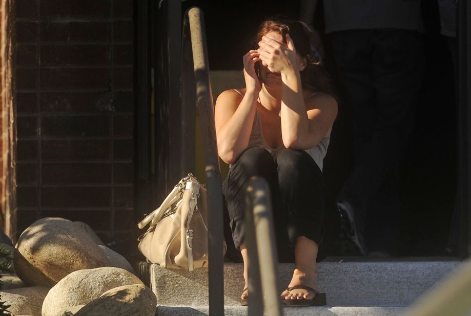 A woman waits for news outside Gateway High School, a few blocks from the scene of the shooting at the Century Aurora 16.