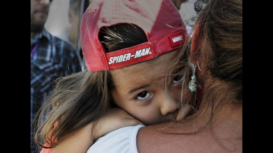 Adariah Legarreta, 4, is comforted by her grandmother Rita Abeyta near the Century 16 Theater in Aurora.