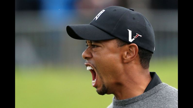 Woods celebrates after holing out from a bunker for birdie on the 18th hole, finishing Friday's second round with a three-under-par 67.
