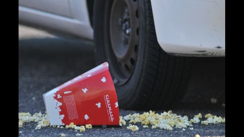 A popcorn box lies on the ground outside the Century 16 movie theater.