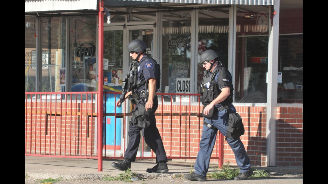 Members of the Aurora Police Department SWAT unit walk near the Holmes' apartment. 