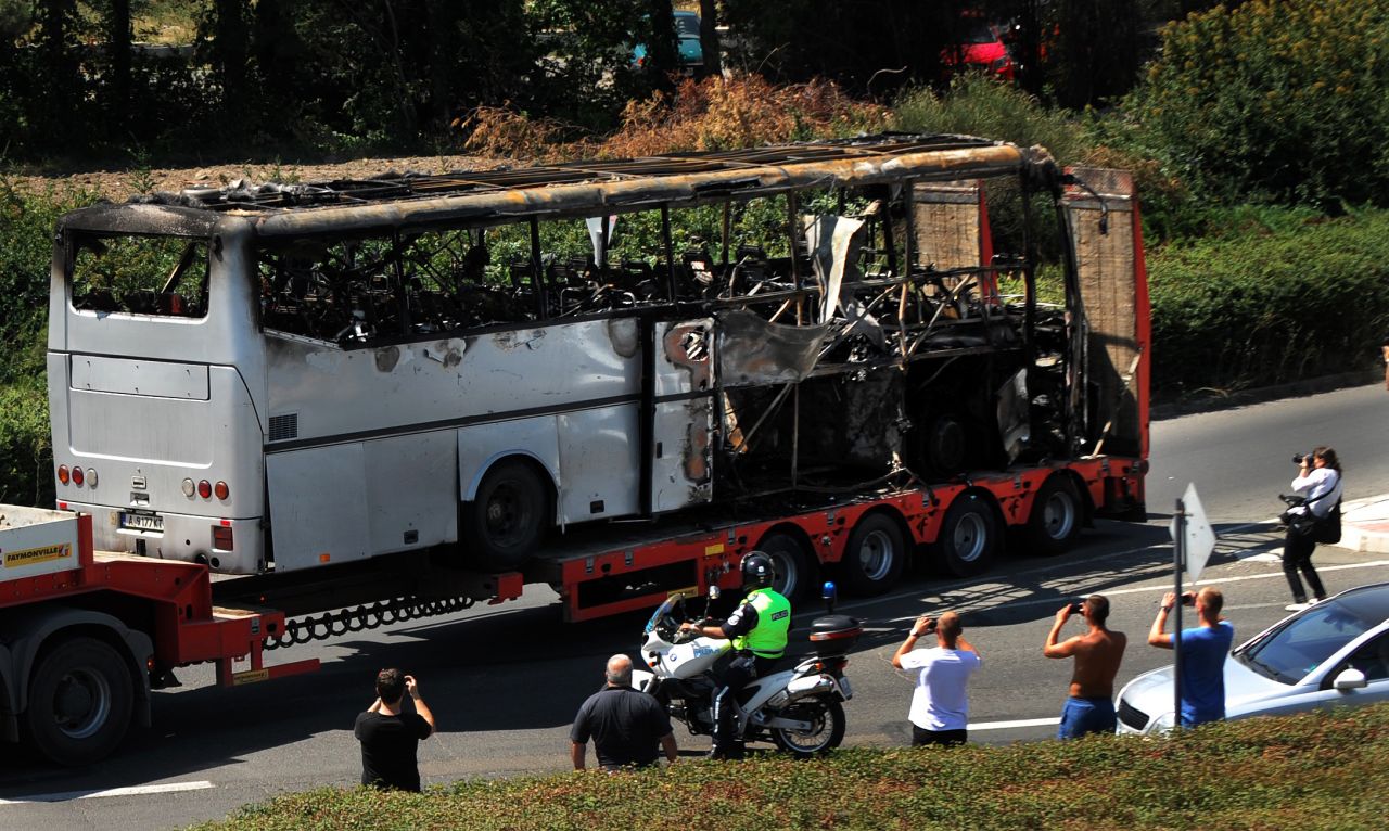 A truck carries the bus damaged by the suicide bomb blast which targeted a group of Israeli tourists in Bulgaria, on Thursday. The suicide bomber was dressed as a tourist carrying fake U.S. ID. Investigators are still trying to find out his identity. 