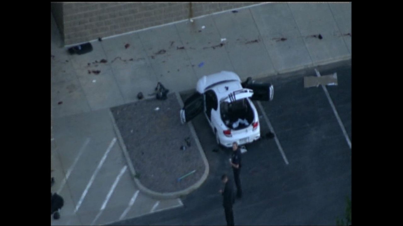 What is believed to be the suspect's car is examined after the shooting. 