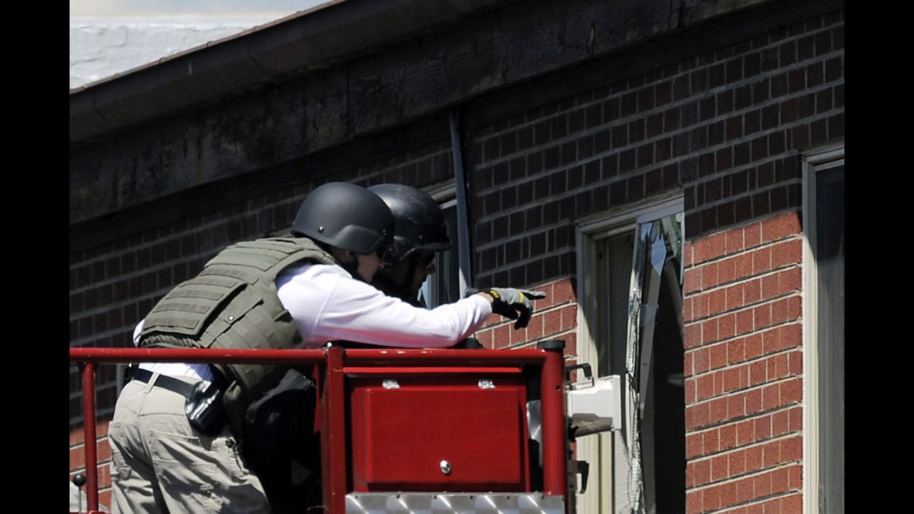 Law enforcement officers prepare to disarm the booby-trapped apartment July 21, 2012.