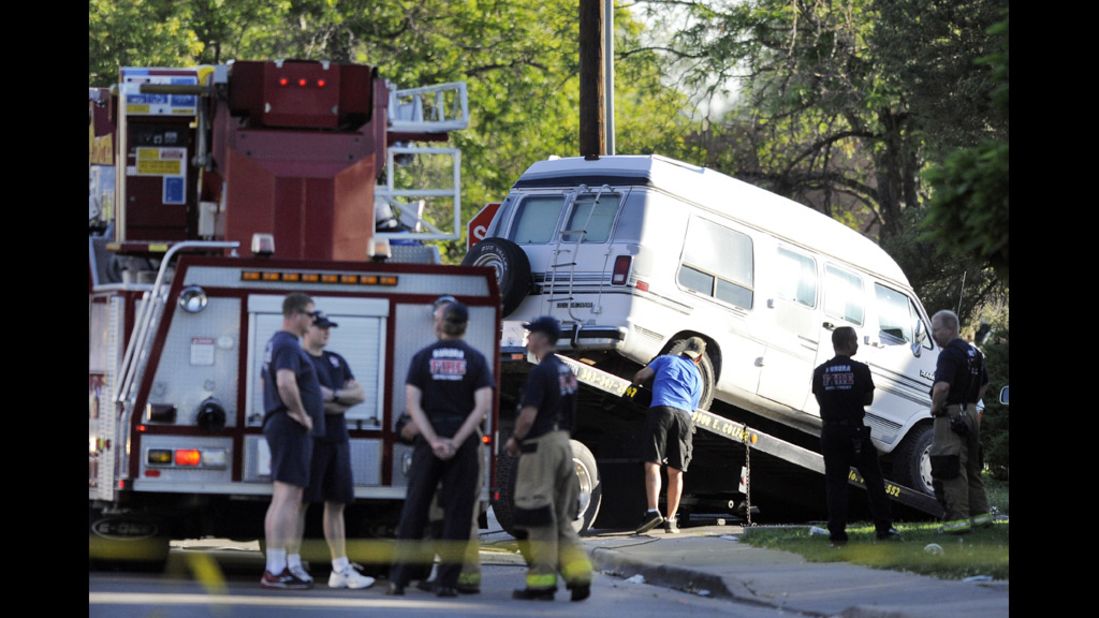 Officials tow cars outside Holmes' apartment July 21, 2012. Police disassembled devices and trip wires set up in the apartment.