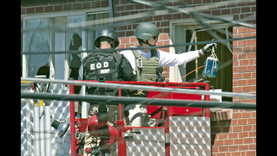 Officers prepare to place an explosive device inside the apartment.