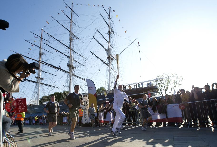 British sailor Sir Robin Knox-Johnston runs around the restored Cutty Sark ship with the London 2012 Olympic Torch in Greenwich, south London, on Saturday July 21.
