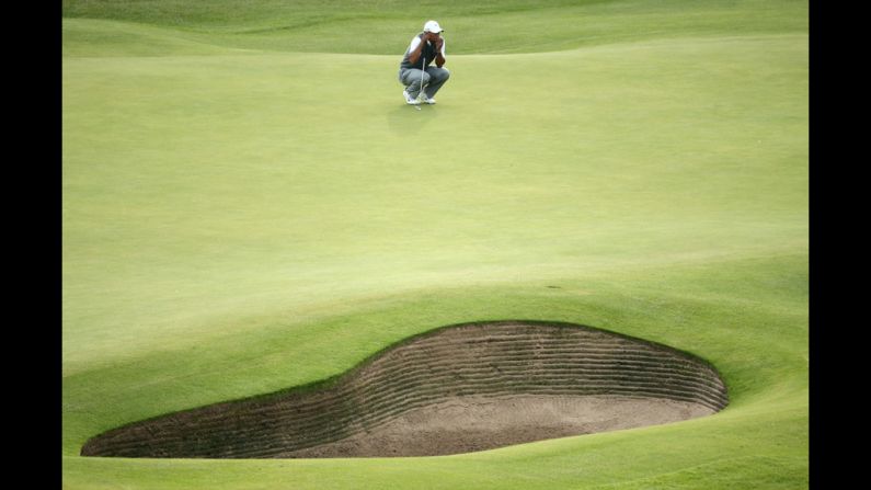 Woods waits to play on the 18th green.