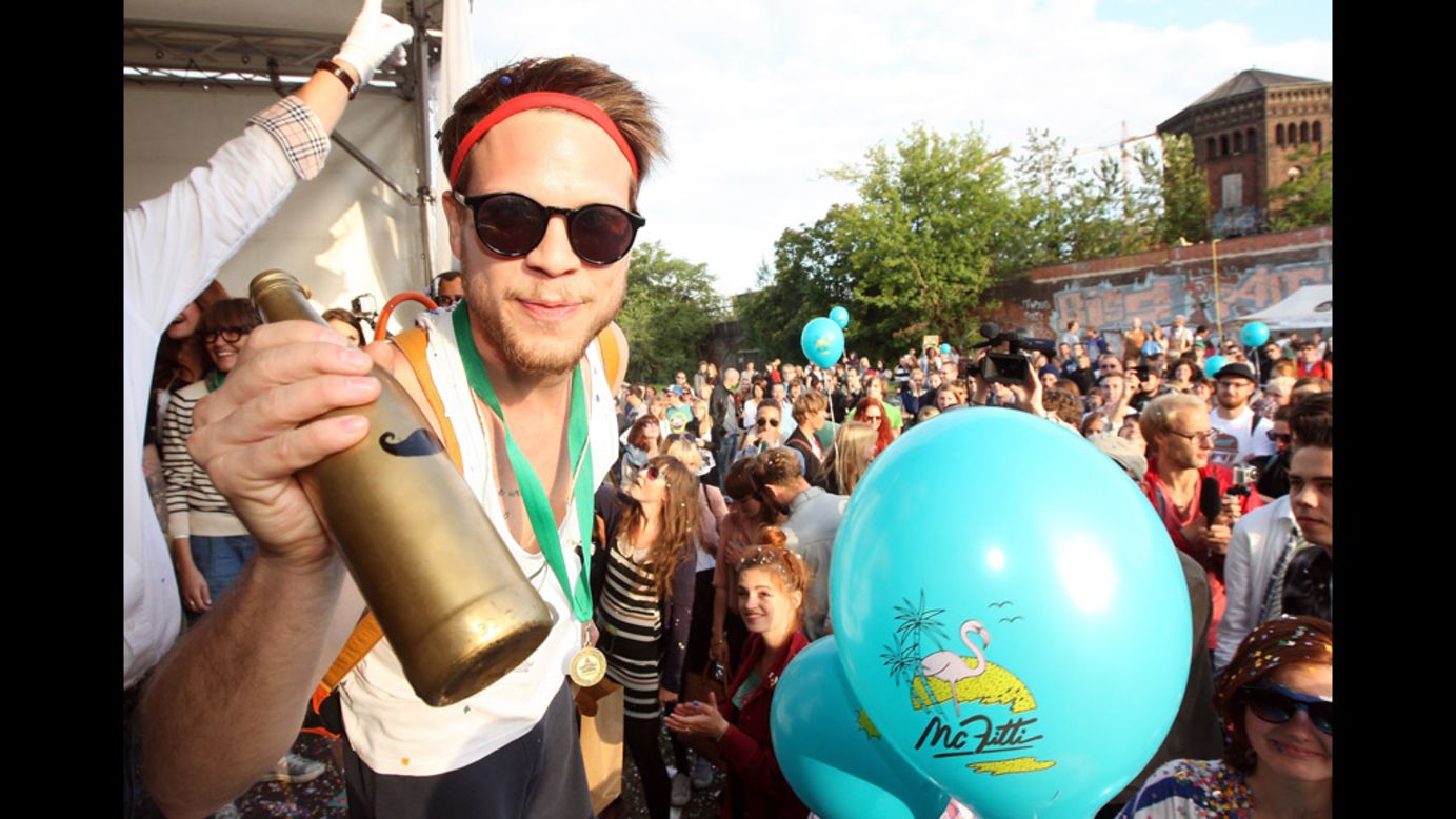 A member of the winning team, Jam FM, holds the "Golden Club Mate" trophy after winning the second annual Hipster Olympics on Saturday, July 21, in Berlin. The games include horn-rimmed-glasses throwing, a vinyl- record-spinning contest, cloth tote sack races and glitter tossing. Click through the gallery to see the event.