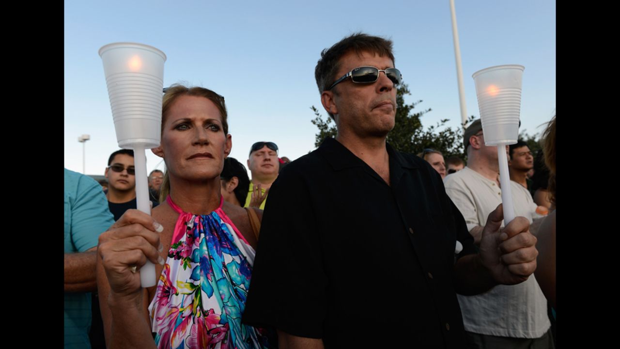 Alicia Prevette, left, and Paul Stepherson attend a vigil for the victims Friday at the Century 16 movie theater.