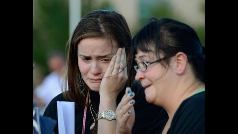Dara Anderson, left, and Monique Anderson cry during a candlelight vigil across the street from the crime scene.