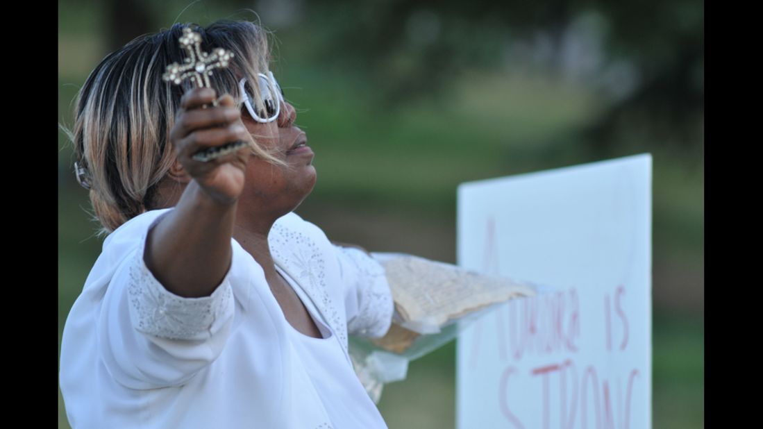 Marietta Perkins of Denver prays for victims and their families.