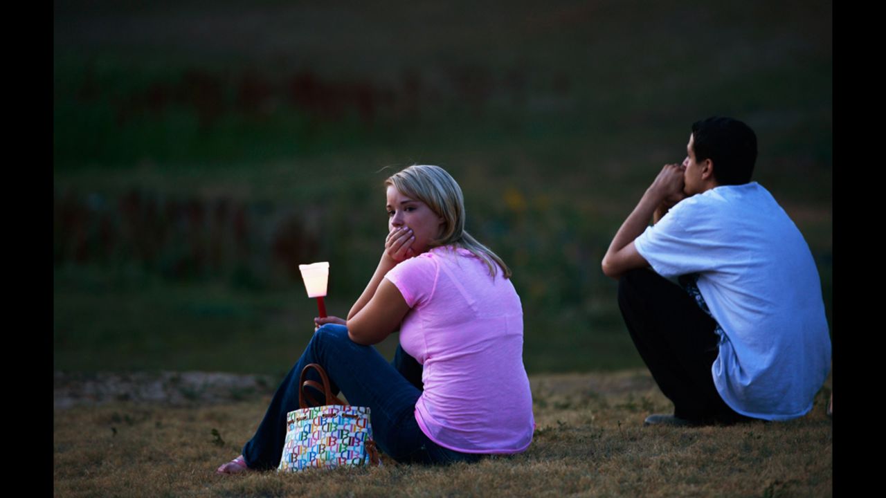 A woman looks at a makeshift memorial after attending a candlelight vigil.