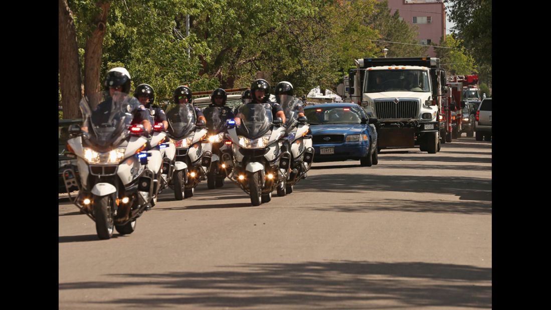 Aurora police escort a sand-filled dump truck containing improvised explosive devices removed from Holmes' booby-trapped apartment on July 21, 2012. Authorities have said they believe the suspect rigged his place before leaving for the movie theater. 