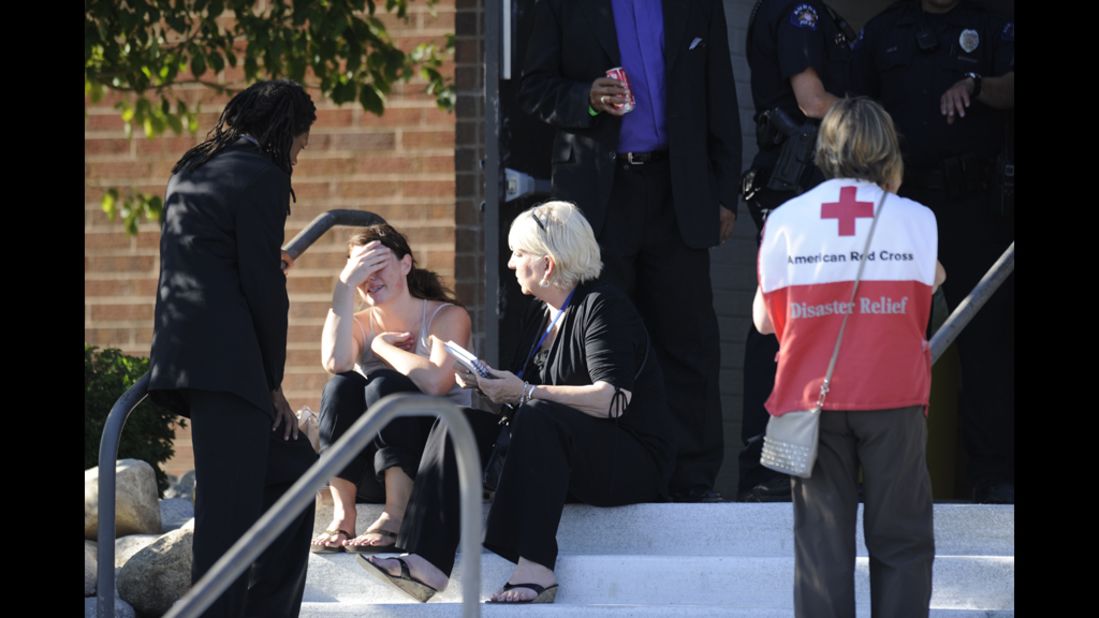 A distraught woman receives counseling from the Rev. Quincy Shannon, left, in front of Gateway High School in Aurora, where the families of the missing met after the shooting.