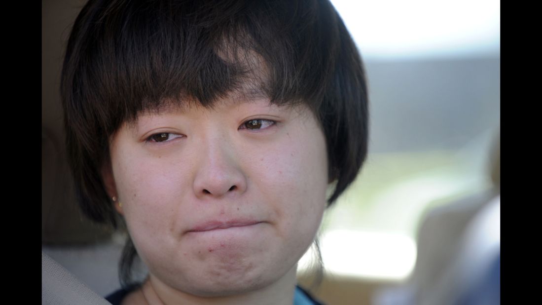 Lin Gan of Aurora holds back tears as she speaks to reporters about her experience in the Century 16 theater.