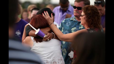Movie theater shooting victim A.J. Boik's girlfriend, Lasamoa Croft, center, embraces his mother during the memorial service.