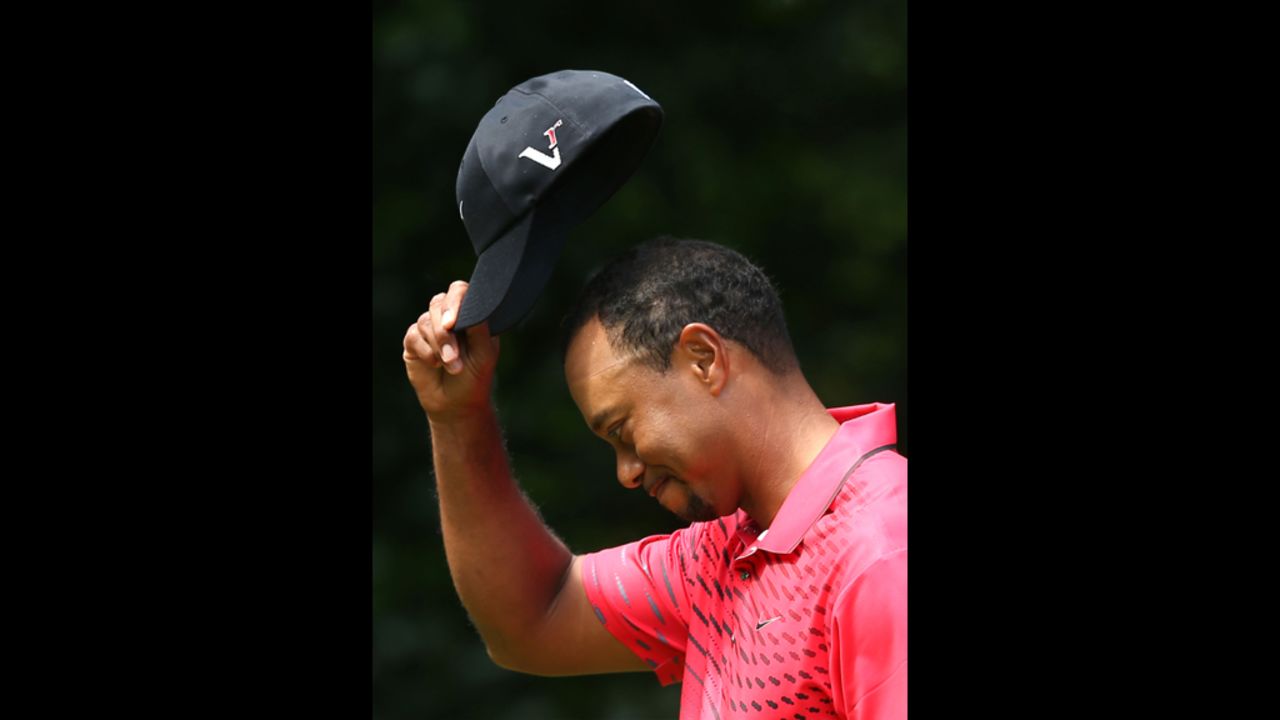 Woods tips his cap to the crowd on Sunday.