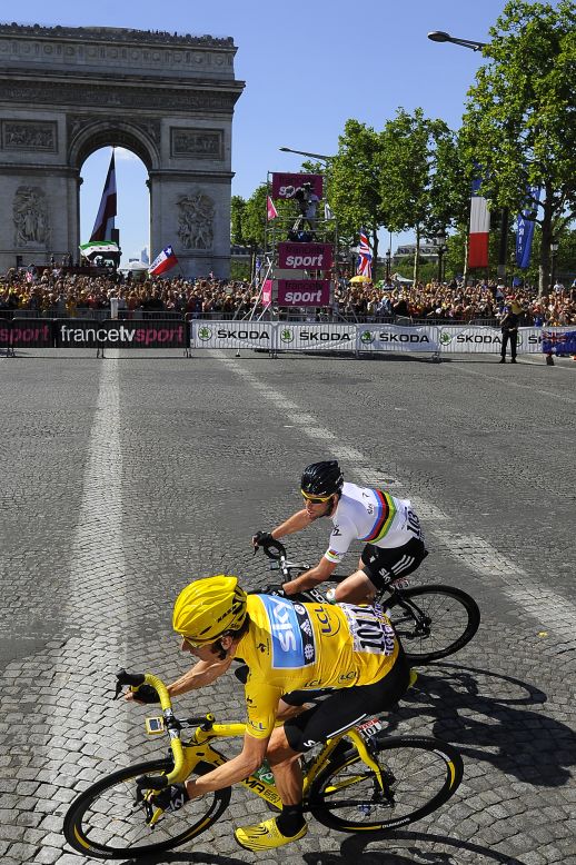 Cavendish and Wiggins, in yellow, ride past the Arc de Triomphe as the three-week race comes to an end in Paris on Sunday.