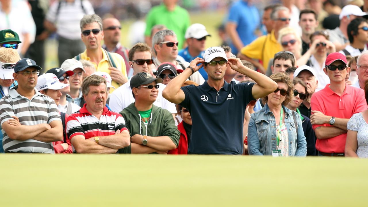 Adam Scott looks at his putting line on a green Sunday.