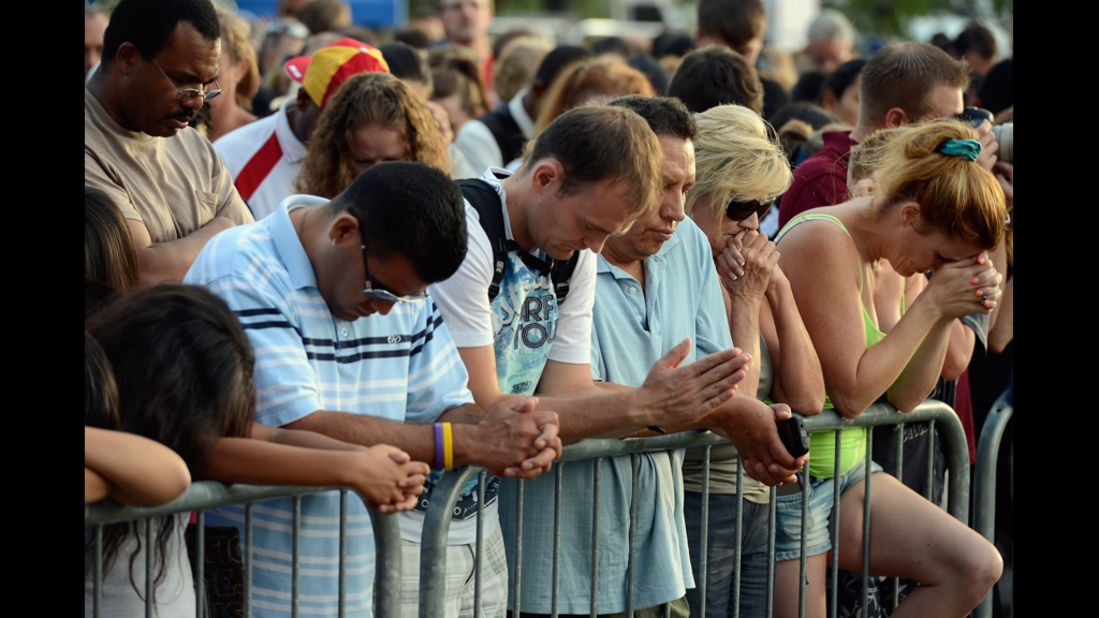 Mourners bow their heads in prayer during the vigil for the victims of the Aurora shooting.