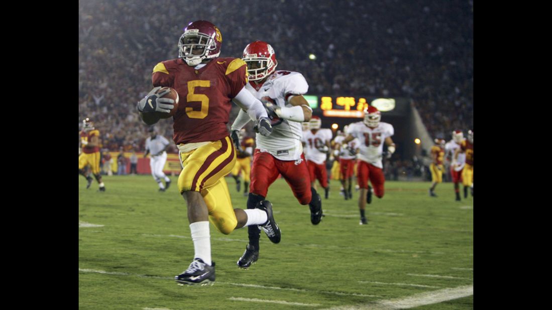 Reggie Bush of the University of Southern California carries the ball past Fresno State's Matt Davis in 2005. The NCAA announced sanctions in June 2010 against USC, finding that Bush and basketball star O.J. Mayo had received lavish gifts. Bush voluntarily forfeited his Heisman Trophy, while USC was given four years' probation, stripped of 30 scholarships and had to vacate 14 wins, including a national championship.