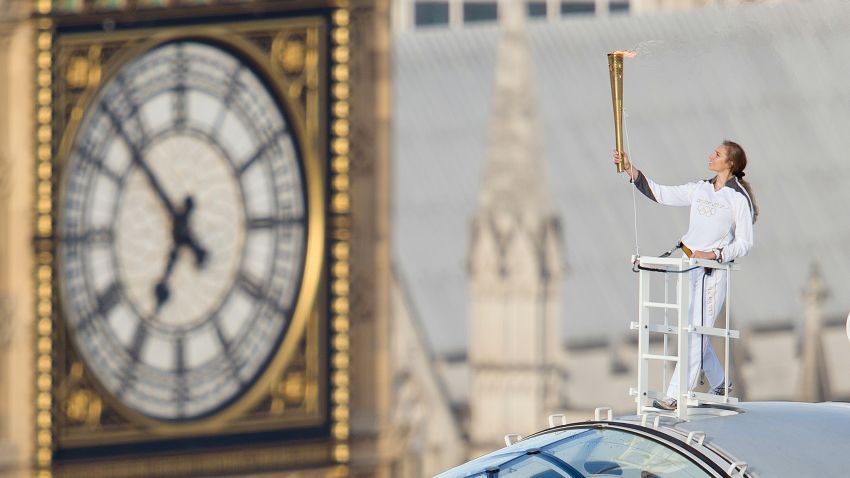 Explorer Amelia Hempleman-Adams holds the Olympic torch a top one of the pods on the London Eye in London on July 22, 2012.
