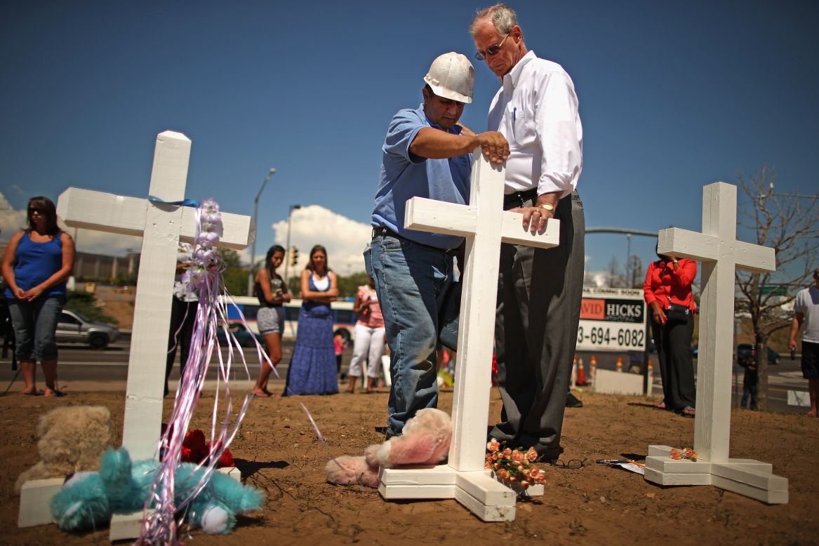 Zanis prays with Aurora Mayor Steve Hogan at the site of 12 crosses to remember those killed in the movie theater massacre.