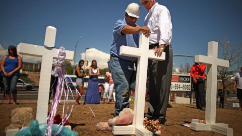 Zanis left 12 crosses to remember those killed in the Aurora, Colorado, theater shooting. Here, he prays with Aurora Mayor Steve Hogan.