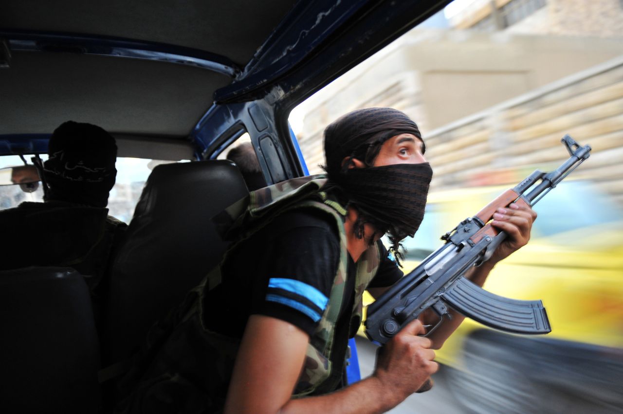 Syrian rebels hunt for snipers after attacking the municipality building in the city center of Selehattin on July 23, 2012.