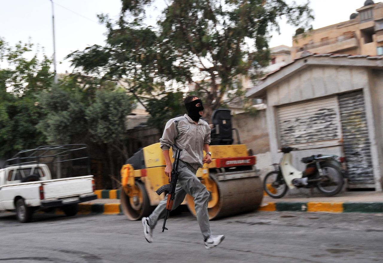 A Syrian rebel runs in a street of Selehattin during an attack on the municipal building on July 23.