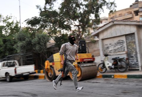 A Syrian rebel runs in a street of Selehattin during an attack on the municipal building on July 23, 2012.