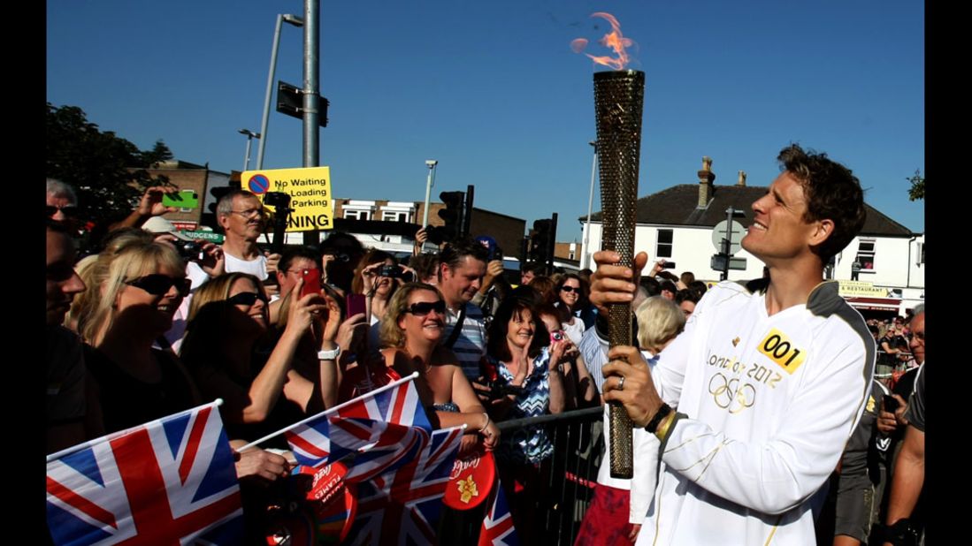 James Cracknell carries the Olympic flame on the torch relay leg through Kingston Upon Thames on Tuesday, July 24. The flame is traveling 2,875 kilometers (1,786 miles) through the United Kingdom over 70 days. Its journey ends Friday at the opening ceremony of the London 2012 Olympic Games.