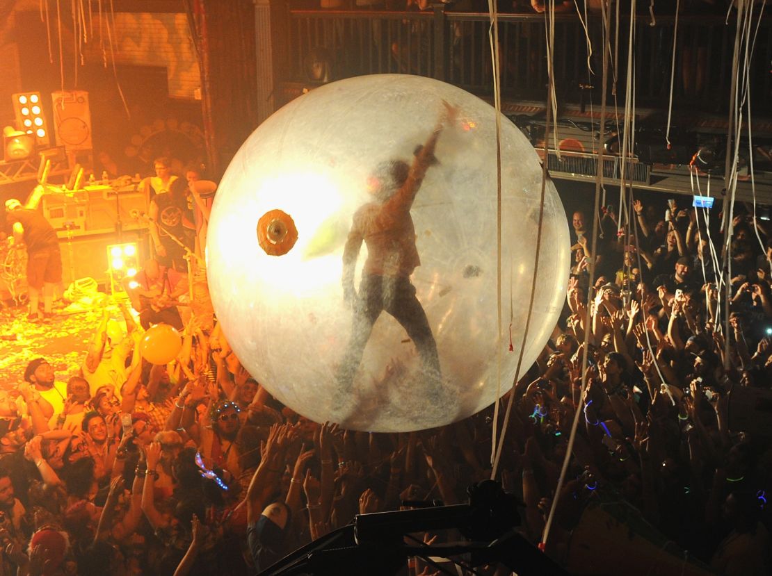The Flaming Lips' Wayne Coyne surfs a concert crowd in his space bubble.