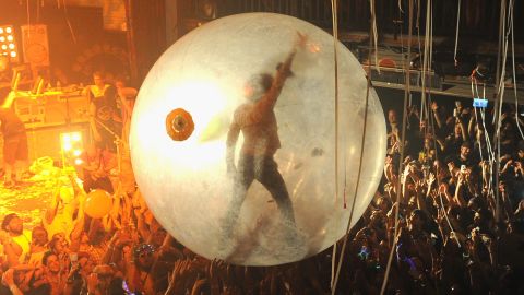 The Flaming Lips' Wayne Coyne surfs a concert crowd in his space bubble.