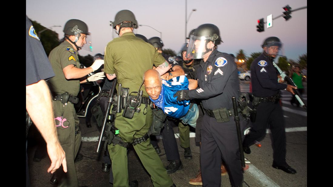 Police take a protester into custody.