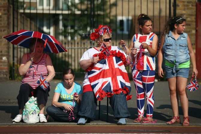 Spectators watch as the flame makes its way up Tottenham High Road on Wednesday, July 25.