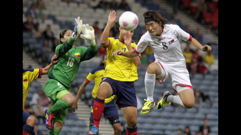 North Korea's Jon Myong Hwa, in white, vies with Colombia's Sandra Sepulveda, in green, and Orianica Velasquez , in yellow, during first-round women's soccer play at Hampden Park on July 25.